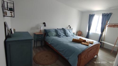 a bedroom with a bed with blue sheets and a window at Une escapade en Luberon in Bonnieux