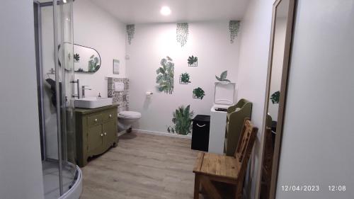 a bathroom with a sink and a toilet with plants on the wall at Une escapade en Luberon in Bonnieux
