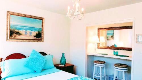 a bedroom with a bed with blue pillows and a counter at Tropical Retreat Close to Beach in Grover Beach