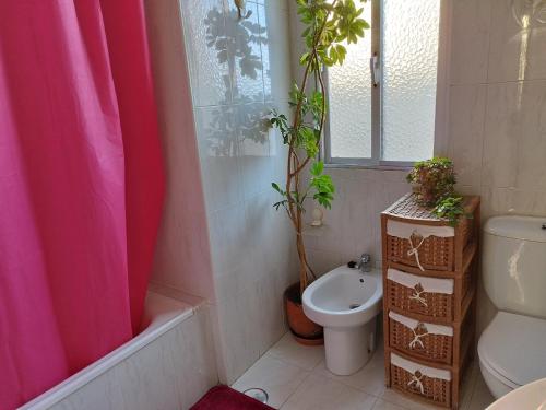 a bathroom with a pink shower curtain and a toilet at Vistas Al Mar E Isla De La Toja in O Grove