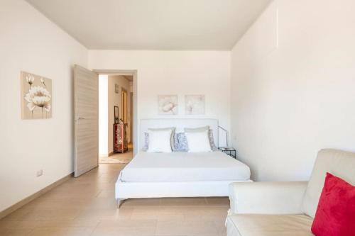 Scano MontiferroにあるAppartamento-L'elicrisoの白いベッドルーム(白いベッド1台、ソファ付)