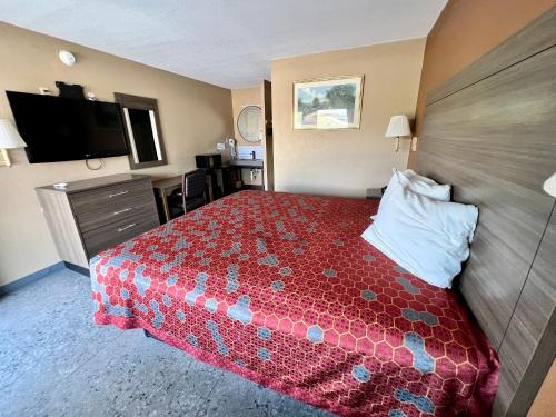 een hotelkamer met een bed en een flatscreen-tv bij THE COUNTRY CORNER INN in Devine