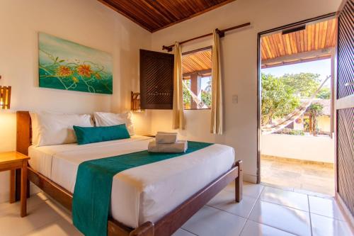 um quarto com uma cama e uma grande janela em Pousada Capitão Thomaz em Jericoacoara