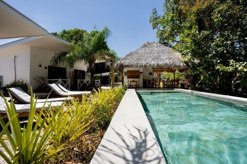 een villa met een zwembad en een resort bij Antema Lodge Secteur Tamarindo, piscine, yoga, gym, jungle et paix in Tamarindo