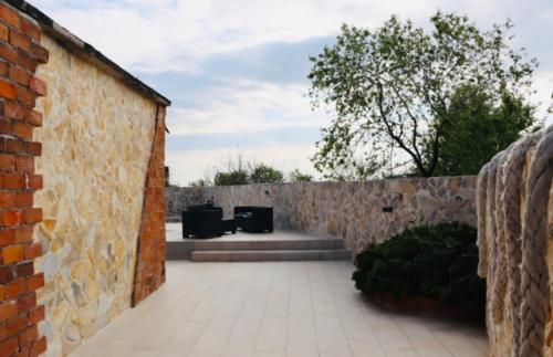 a brick wall with two trash cans in a courtyard at Iva apartman sa bazenom in Donji Zemunik