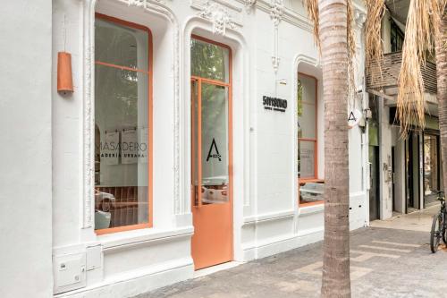 5411 Soho Hotel في بوينس آيرس: واجهة متجر مع باب برتقالي على شارع