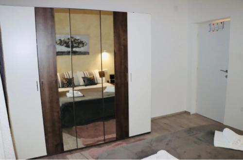 einen Spiegel in einem Zimmer mit einem Bett in einem Schlafzimmer in der Unterkunft Iva apartman sa bazenom in Donji Zemunik
