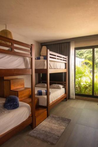 a bedroom with four bunk beds and a window at Casa Mar Bacalar in Chetumal