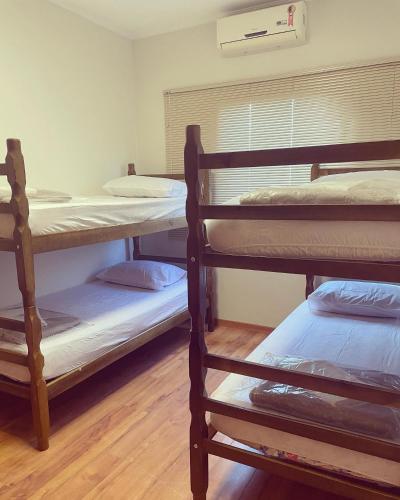 a room with three bunk beds in a room at Pousada & Hostel São Carlos in São Carlos