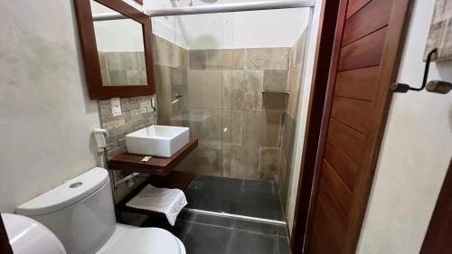 a small bathroom with a toilet and a shower at Aki Pousada in São Miguel do Gostoso