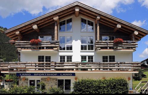 a large white building with a wooden roof at MOUNTAIN LODGE OBERJOCH, BAD HINDELANG - moderne Premium Wellness Apartments im Ski- und Wandergebiet Allgäu auf 1200m, Family owned, 2 Apartments mit Privat Sauna in Bad Hindelang