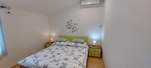 ein kleines Schlafzimmer mit einem Bett und zwei Nachttischen in der Unterkunft Adriana Apartment in Mali Lošinj