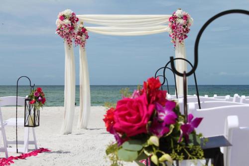 a table and chairs on the beach with flowers at Resort at Longboat Key Club in Sarasota