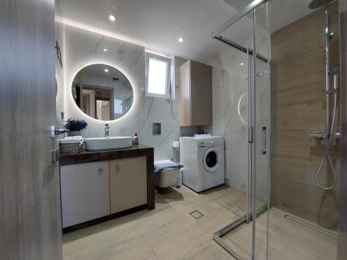een badkamer met een wastafel, een toilet en een spiegel bij Endless View Apartment in Nafplio