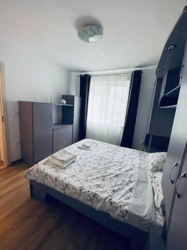 Habitación pequeña con cama y ventana en A's apartment en Onești