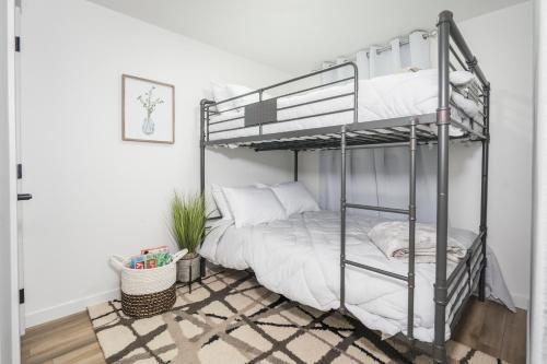 een slaapkamer met een stapelbed met witte lakens bij Beautiful Remodeled Home 3 BD 1 BTH w Hot Tub in Spokane Valley