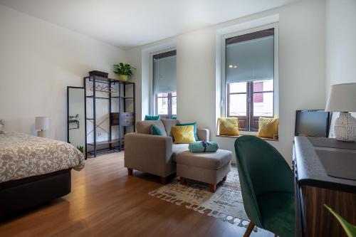 a bedroom with a bed and a chair and a desk at Casa Esmeralda by Home Sweet Home Aveiro in Aveiro