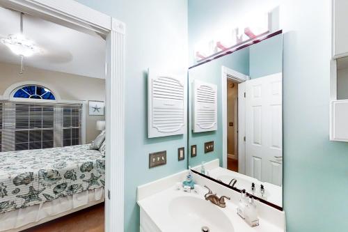 baño con lavabo, espejo y cama en Riverwalk 301 en Myrtle Beach