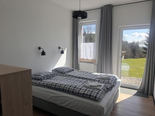 1 dormitorio con cama y ventana grande en Morze Gór en Duszniki Zdrój