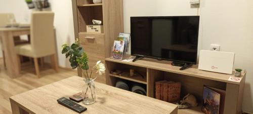 a living room with a television and a table at Sweet apartment in Subotica