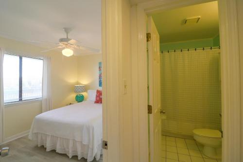 a bedroom with a bed and a bathroom with a shower at 33C Lighthouse Point in Tybee Island