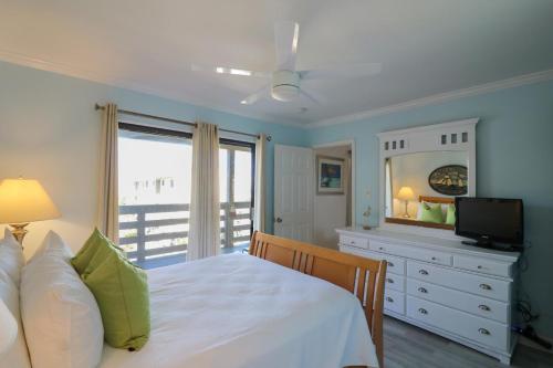 a bedroom with a white bed and a television at 33C Lighthouse Point in Tybee Island