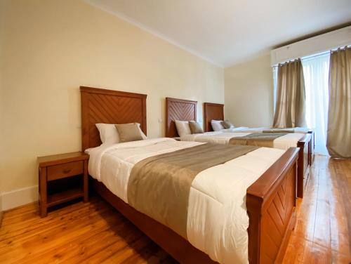 2 łóżka w sypialni z drewnianą podłogą w obiekcie Cairo House Hostel w Kairze