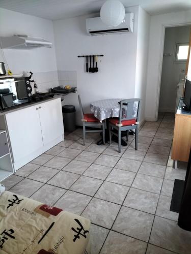 une cuisine avec une table et des chaises dans une pièce dans l'établissement Maisonnée avec une chambre, à Saint-Michel-en-lʼHerm