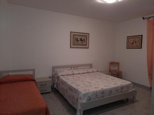 a bedroom with two beds and a chair and a bed at DESULO casa vacanze in Desulo