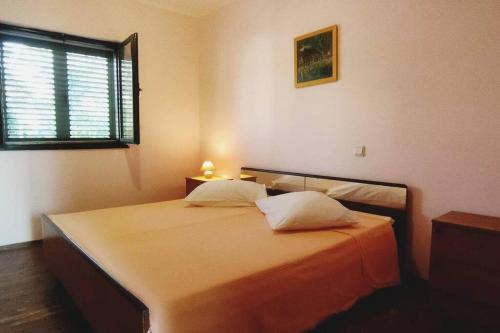 um quarto com uma cama com duas almofadas e uma janela em Apartment Prvic Sepurine II em Prvic Sepurine