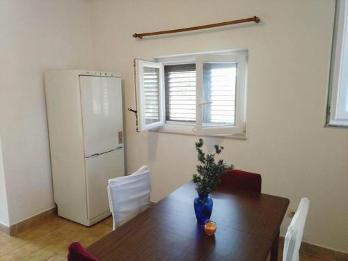 a kitchen with a wooden table and a refrigerator at Apartment Prvic Sepurine II in Prvić Šepurine