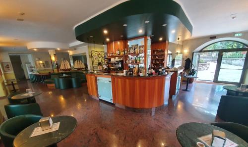 a bar in a restaurant with tables and chairs at Hotel Azalea in Baveno