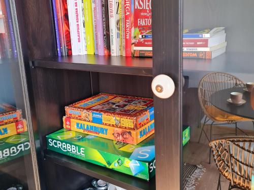 a book shelf filled with books on top at Apartament Mazury in Giżycko