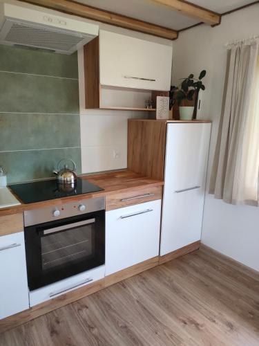 a kitchen with white cabinets and a stove at Leszczynowe Zacisze in Wiele