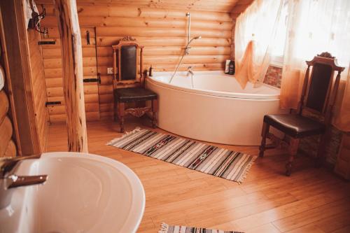 a bathroom with a bath tub and a sink at Tradiția borsanului in Borşa