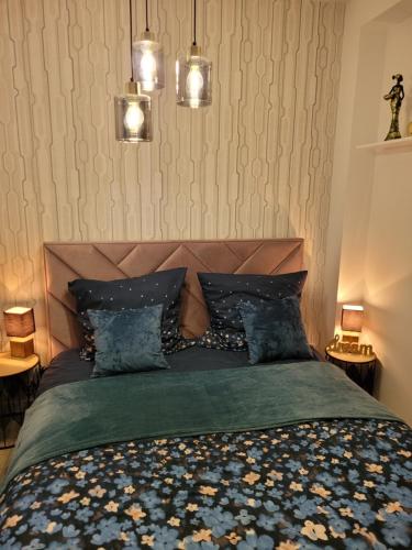 a bedroom with a bed with a green blanket and two lights at Apartament Nina in Jelenia Góra