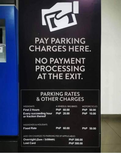 a sign for pay parking charges at the airport at Luxurious Condotel at the heart of Makati in Manila