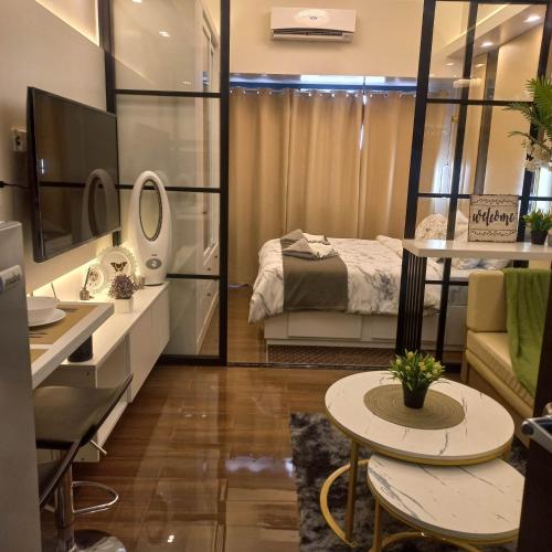 a room with a bed and a desk and a table at Luxurious Condotel at the heart of Makati in Manila
