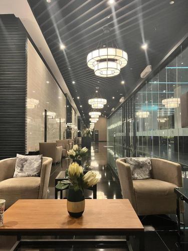 a lobby with a table and chairs and a chandelier at Luxurious Condotel at the heart of Makati in Manila