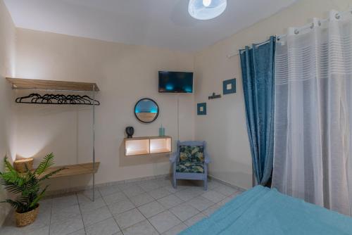 a living room with a chair and a window at Sarita's Apartments & Suite in Laganas