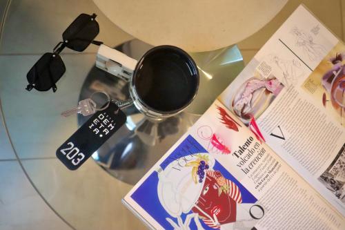 een glazen tafel met een kopje en een tijdschrift bij Hotel Demetria in Huánuco