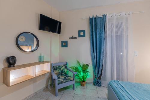 a bedroom with a tv and a chair and a mirror at Sarita's Apartments & Suite in Laganas
