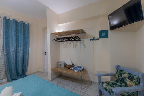 a living room with a couch and a tv and a chair at Sarita's Apartments & Suite in Laganas