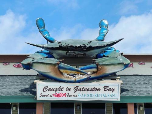 uma grande estátua de um caranguejo no topo de um edifício em Gaido's Seaside Inn em Galveston