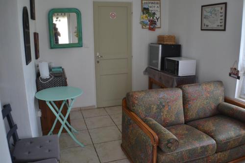 un soggiorno con divano e tavolo di accommodation à la ferme - appartement et mobilhome a Lubersac