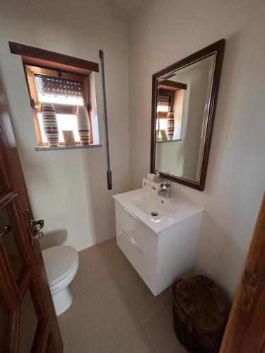 een badkamer met een toilet, een wastafel en een spiegel bij Casa Vicente in Lamego