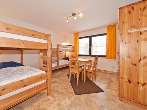 ein Schlafzimmer mit Etagenbetten sowie einem Tisch und Stühlen in der Unterkunft Holiday home Reichenbach in Bayerstetten