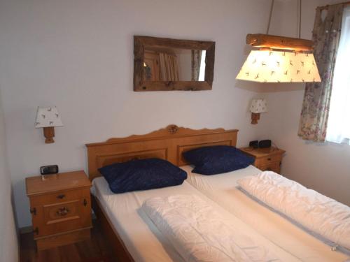 a bedroom with two beds with blue pillows and a mirror at Holiday home Karwendel in Füssen