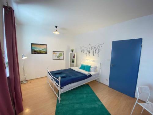 una camera da letto con un letto con lenzuola blu e un tappeto verde di Boho Studio - Brno Cejl a Brno