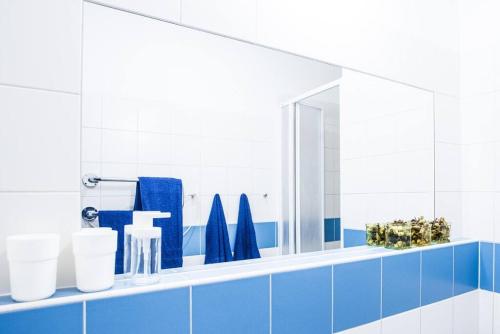 een badkamer met een spiegel en blauwe tegels bij Boho Studio - Brno Cejl in Brno